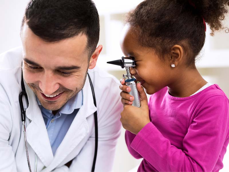 Girl checking an Audiologist's hearing.