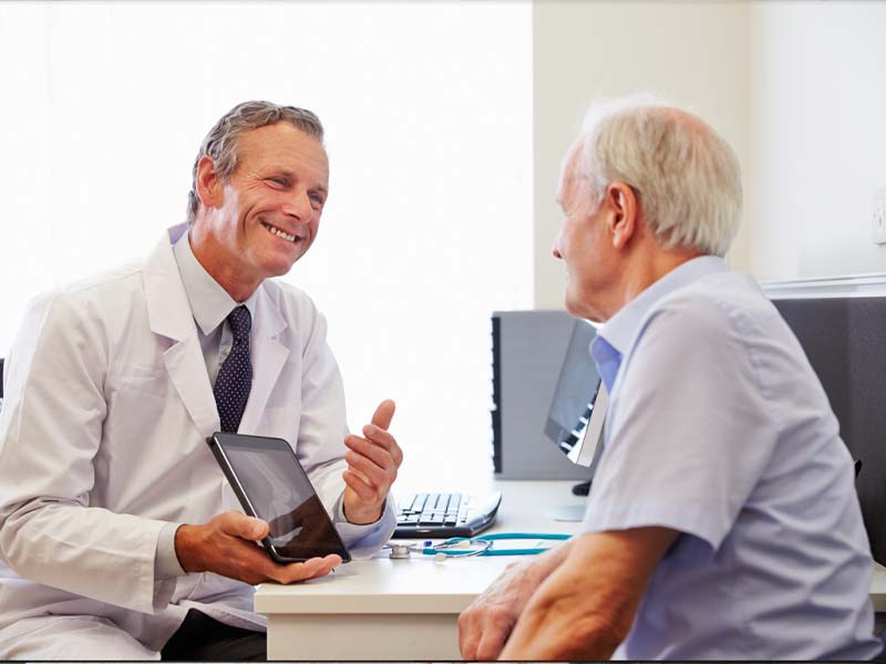 Audiologist talking with a man.