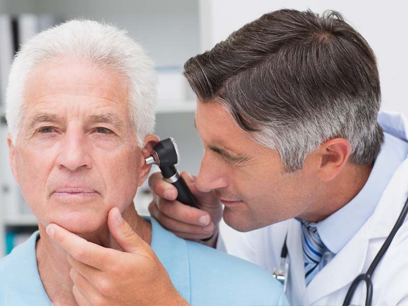 Audiologist checking a man's hearing.