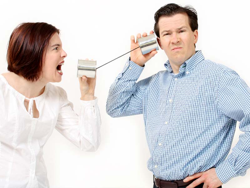 Photo of man and woman talking through a can