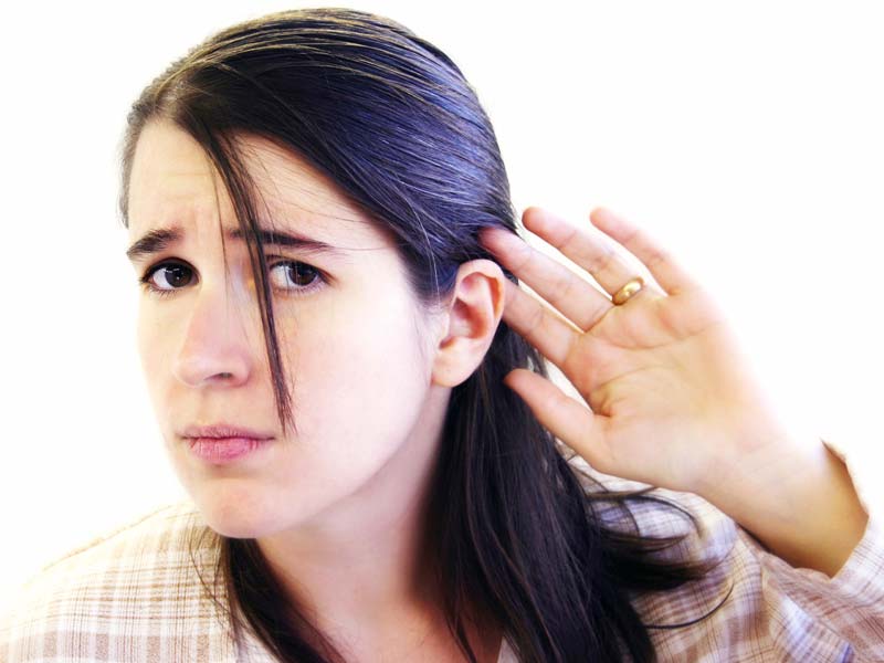 Woman holding her ear.