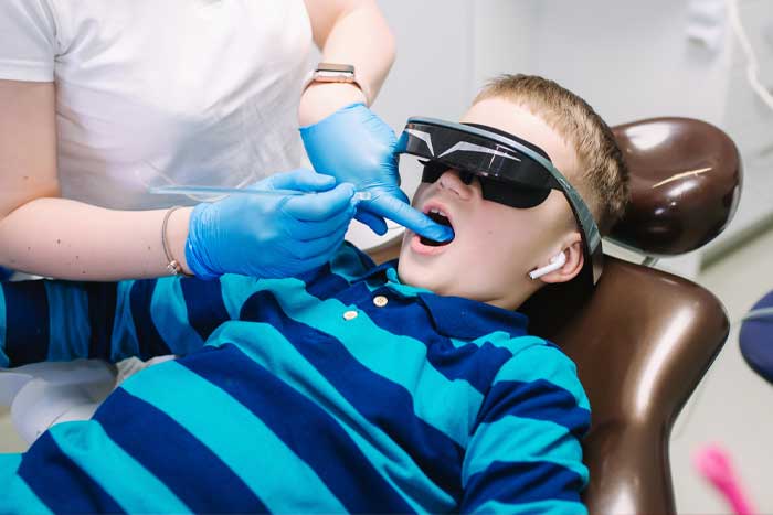 Boy getting dental treatment while practicing Audio Analgesia